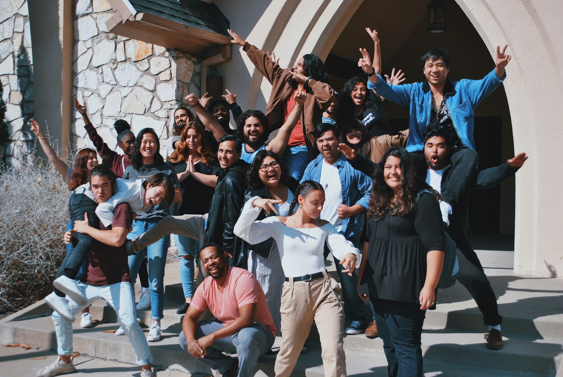 A large culturally diverse group of teens smiling together outside
